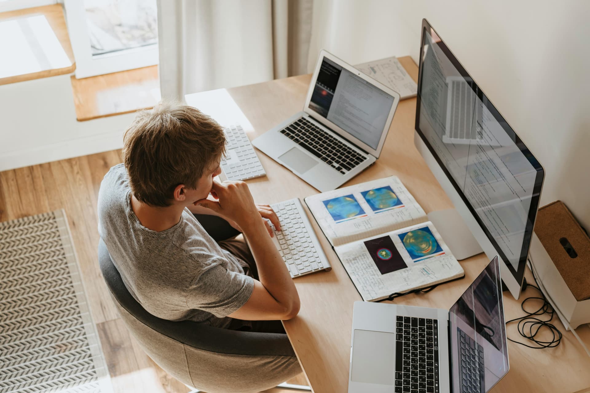 A person sitting in front of multiple computer screens.
