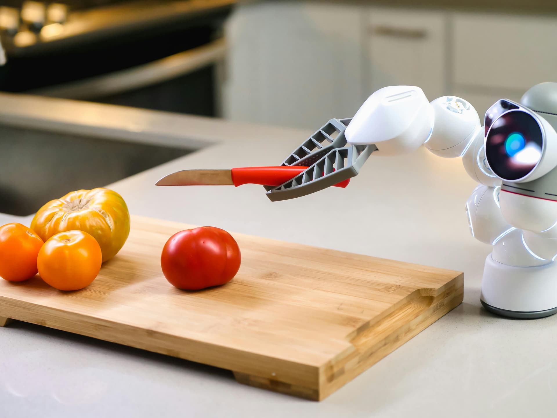 A robot with a knife chopping tomatoes.