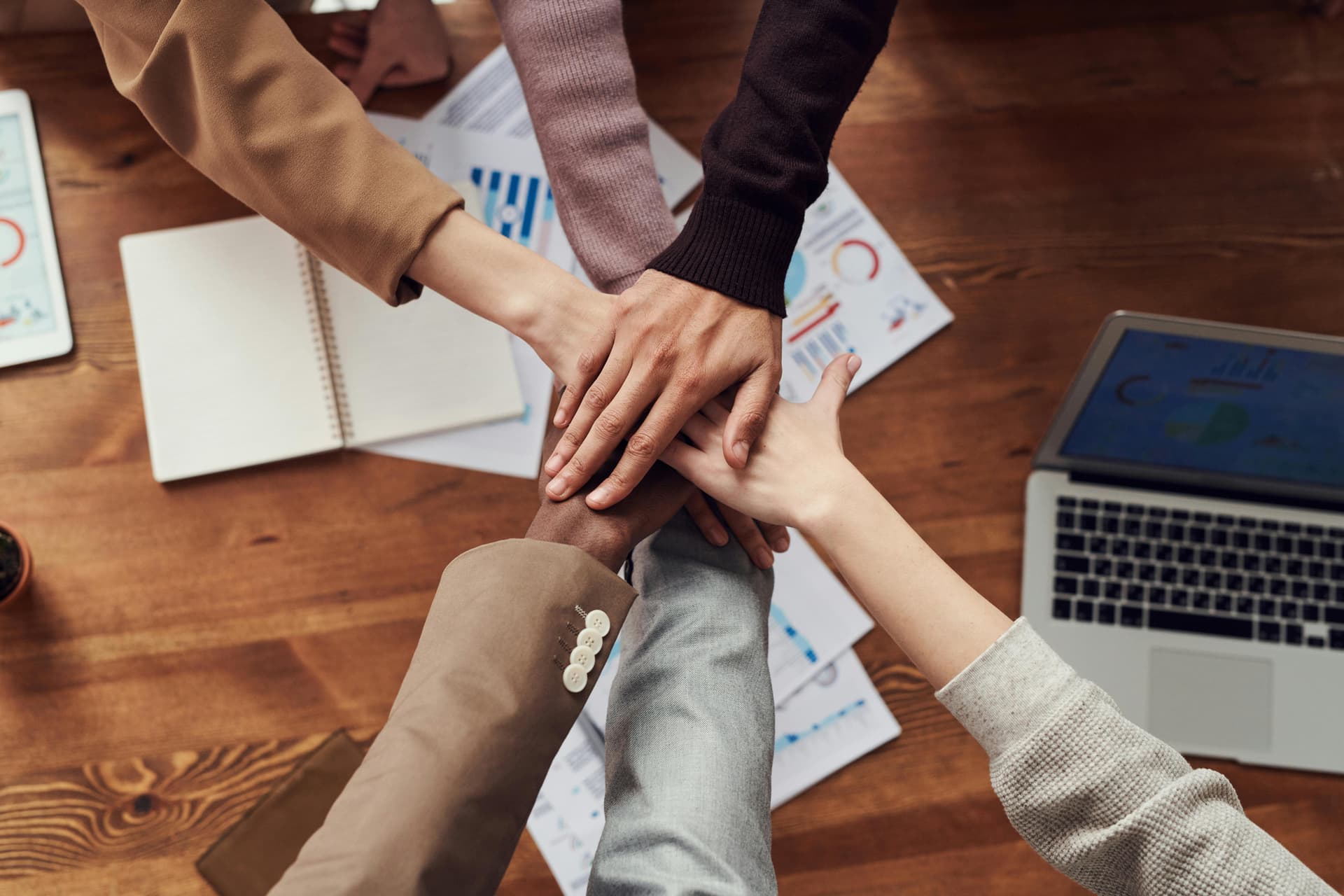 Team members joining hands.